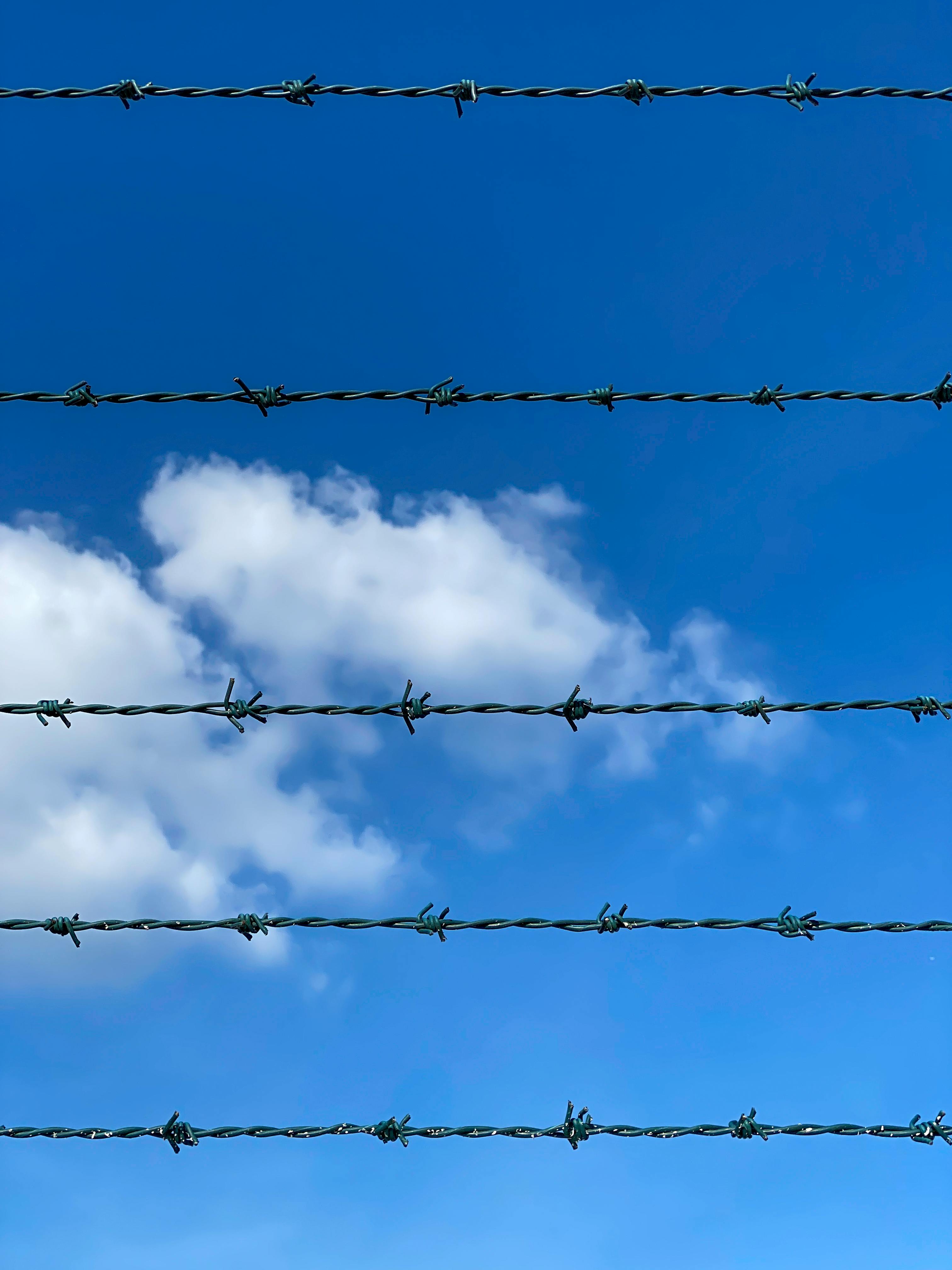 Barbed wire fence against blue Texas sky